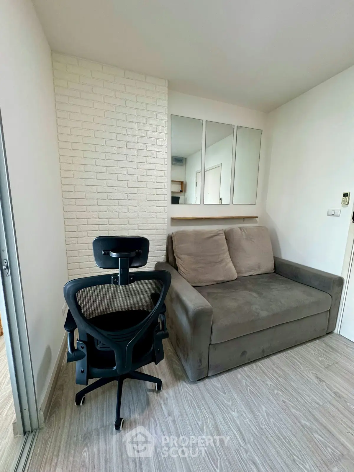 Cozy study room with modern chair and comfortable sofa in a bright apartment.