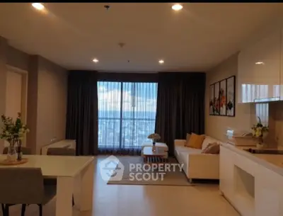 Spacious modern living room with city view, open kitchen, and elegant decor.