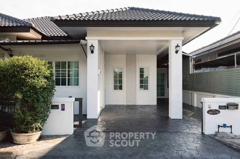 Charming single-story home with modern exterior and spacious driveway in a serene neighborhood.