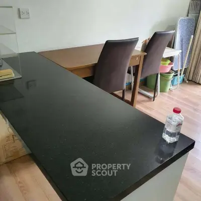 Modern kitchen with sleek black countertop and dining area