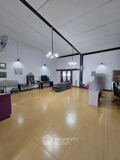 Spacious living room with high ceilings and modern lighting, perfect for family gatherings.