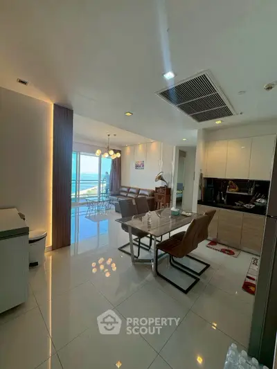 Modern open-plan living and dining area with ocean view and stylish furnishings.