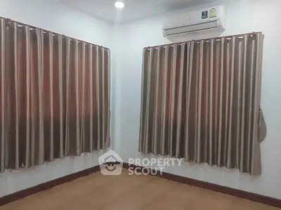 Spacious room with elegant curtains and air conditioning, perfect for a cozy living space.