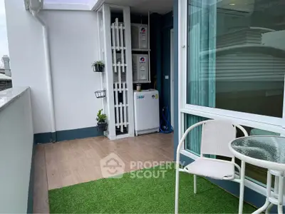 Charming balcony with artificial grass and cozy seating, perfect for relaxation and enjoying city views.