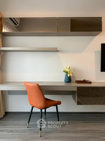 Modern study room with sleek desk, stylish chair, and elegant decor in a contemporary apartment.
