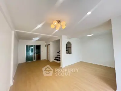 Spacious open-plan living room with modern lighting and wooden flooring