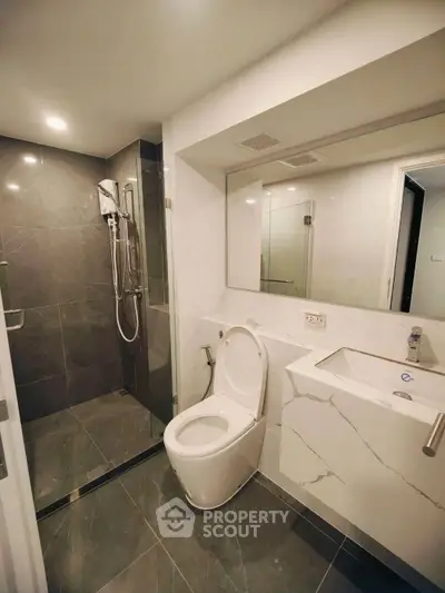 Modern bathroom with sleek design, featuring a glass shower and elegant fixtures.
