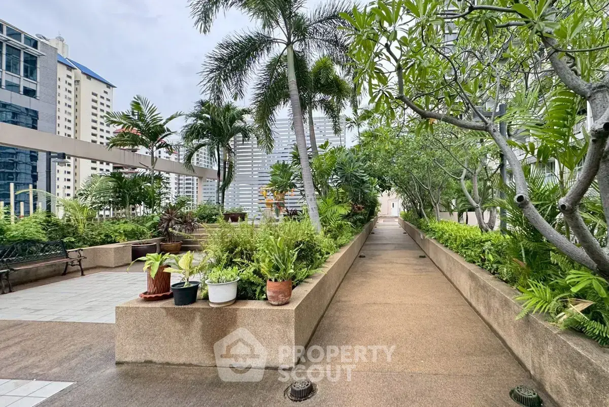 Lush rooftop garden with city views and tropical plants in a modern building.