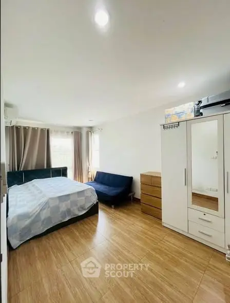 Spacious bedroom with modern furnishings and natural light