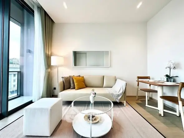 Modern living room with stylish furniture and large windows offering natural light and city views.