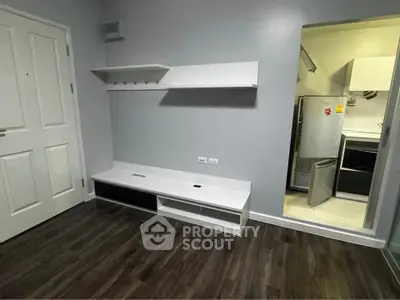 Modern apartment interior with sleek white shelving and kitchen view, perfect for urban living.