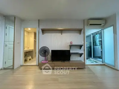 Modern living room with TV, fan, and air conditioning in a cozy apartment.
