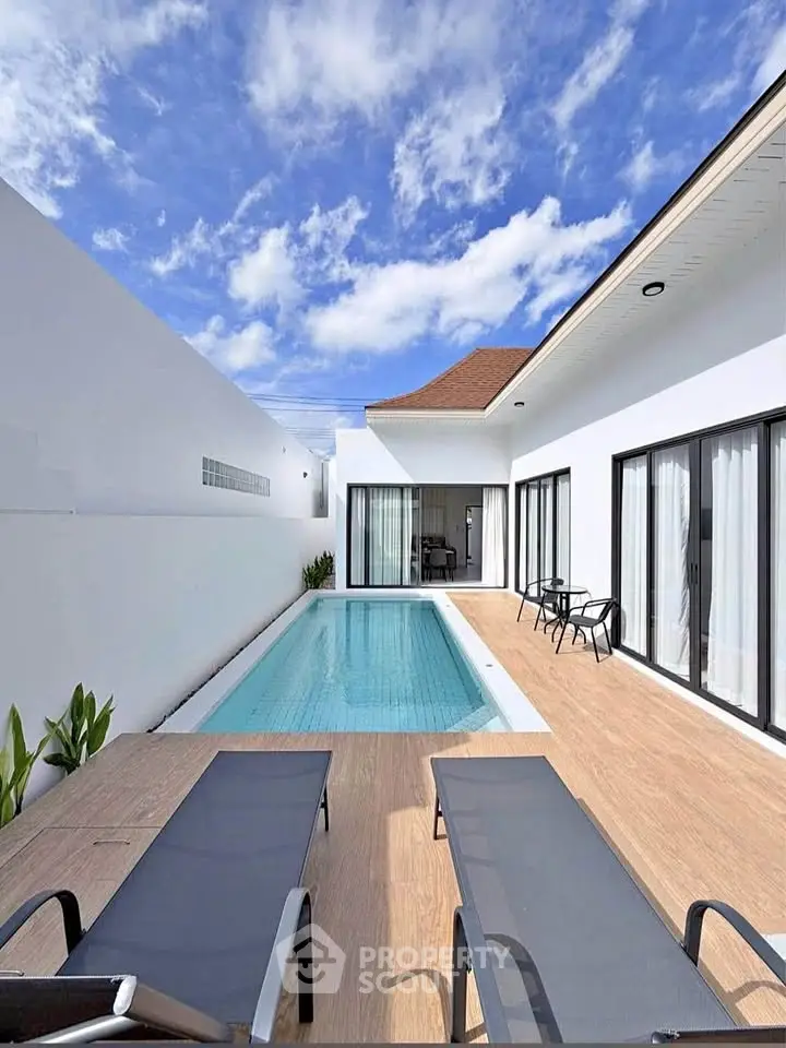 Luxurious modern villa with private pool and spacious patio under a clear blue sky.