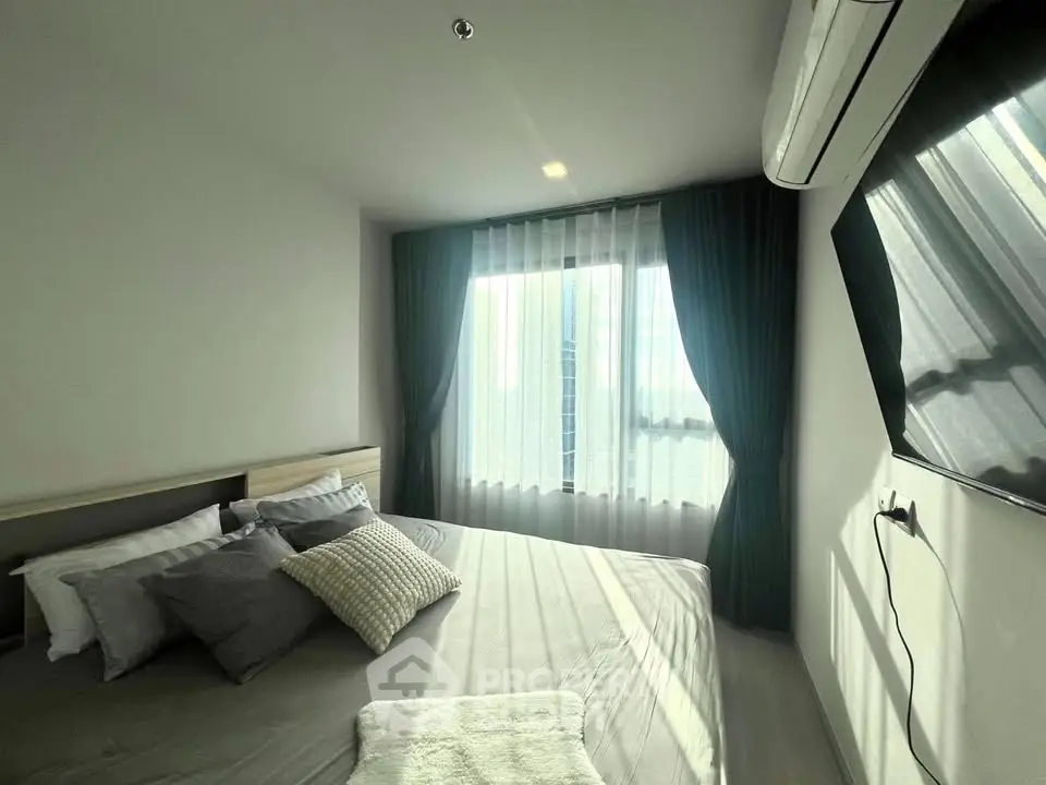 Modern bedroom with large window and air conditioning, featuring a cozy bed and stylish decor.