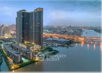 Stunning riverside high-rise building with panoramic city views at dusk.