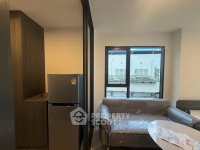 Modern apartment interior with cozy living area and large window view.