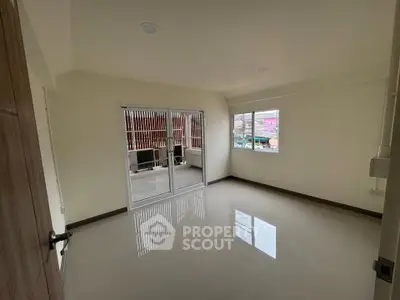 Spacious unfurnished room with large windows and sliding glass doors leading to a balcony.