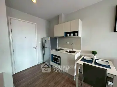Modern compact kitchen with sleek cabinetry and dining area