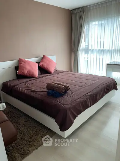Modern bedroom with stylish decor and natural light, featuring a cozy bed and elegant curtains.