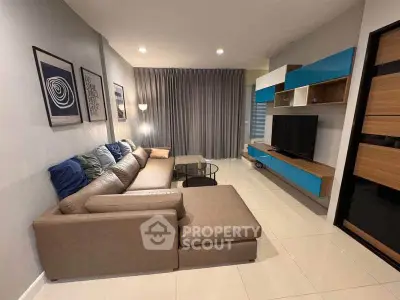 Modern living room with stylish sectional sofa and sleek entertainment unit.