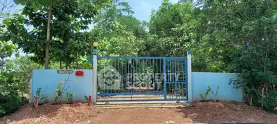 Charming blue gate entrance surrounded by lush greenery, perfect for a serene property.