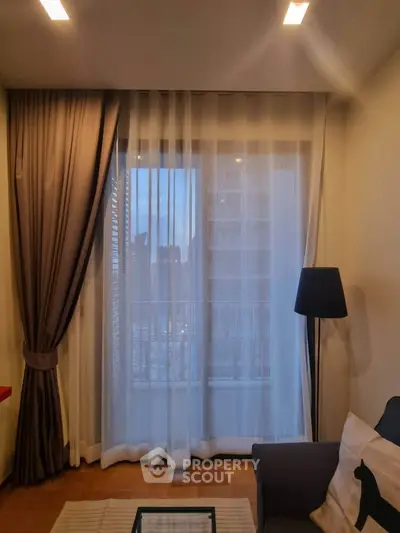 Cozy living room with elegant curtains and a modern floor lamp, perfect for relaxation.
