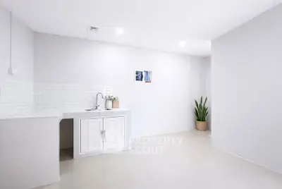Minimalist kitchen with white cabinetry and sleek tile backsplash