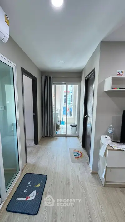 Modern apartment hallway with wooden flooring and balcony view