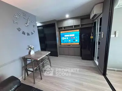 Modern living room with sleek furniture and wall-mounted TV, featuring stylish decor and ample natural light.