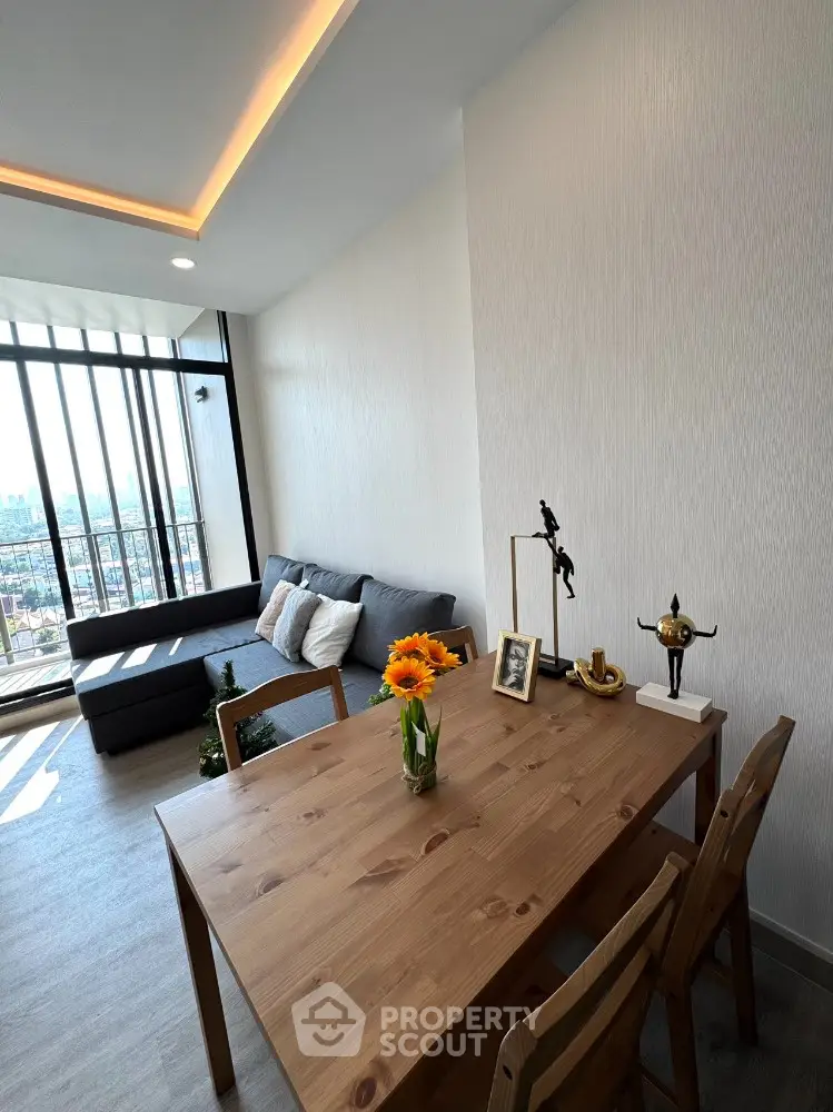 Modern living room with stylish decor and large windows offering city views