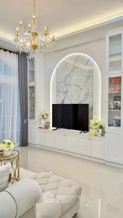 Luxurious living room with elegant chandelier and marble TV wall