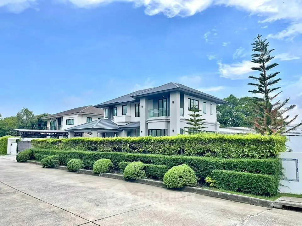 Luxurious modern house with lush greenery and spacious driveway