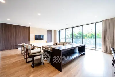 Spacious modern living room with large windows and elegant wooden flooring.