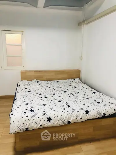 Cozy bedroom with wooden bed frame and star-patterned bedding
