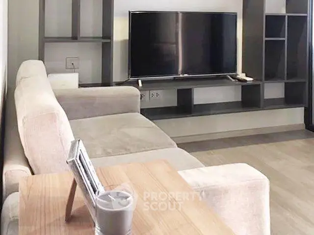 Modern living room with sleek TV unit and cozy beige sofa