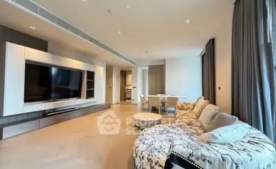 Spacious modern living room with elegant decor and large TV, perfect for relaxation and entertainment.