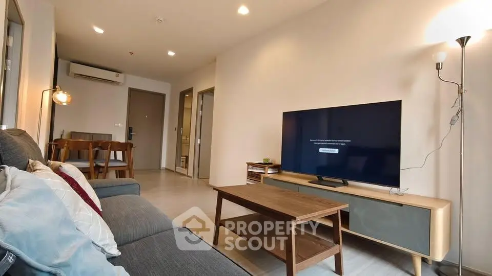 Modern living room with stylish furniture and large TV, perfect for relaxation and entertainment.