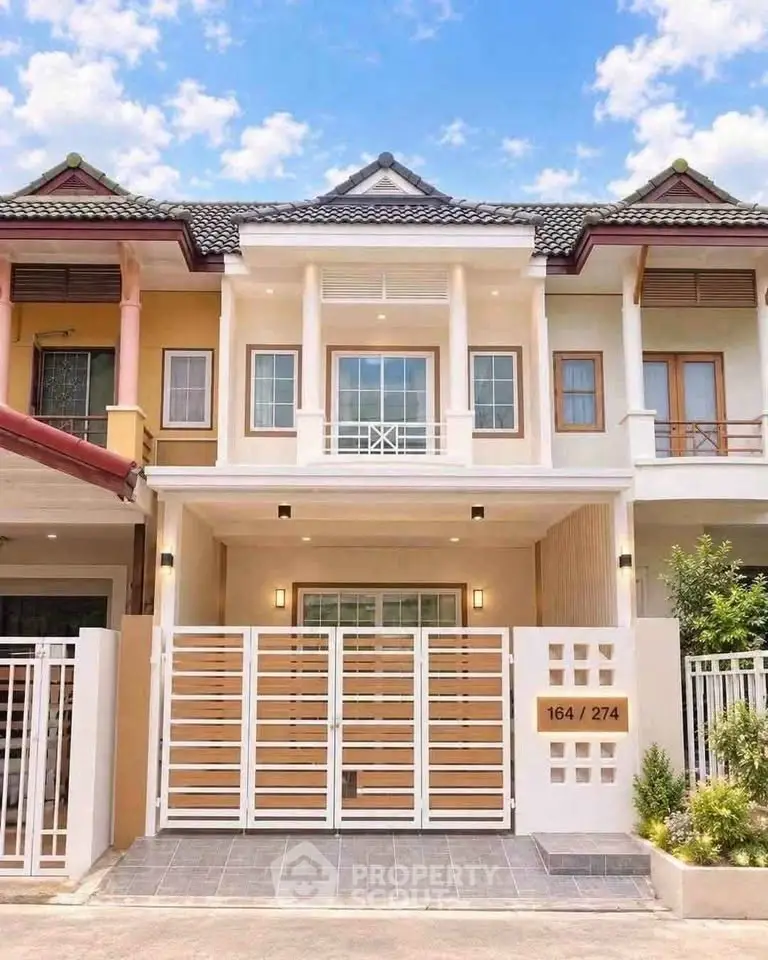 Charming two-story townhouse with modern facade and gated entrance in a serene neighborhood.