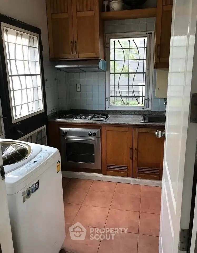 Compact kitchen with gas stove and washing machine, ideal for small apartments.