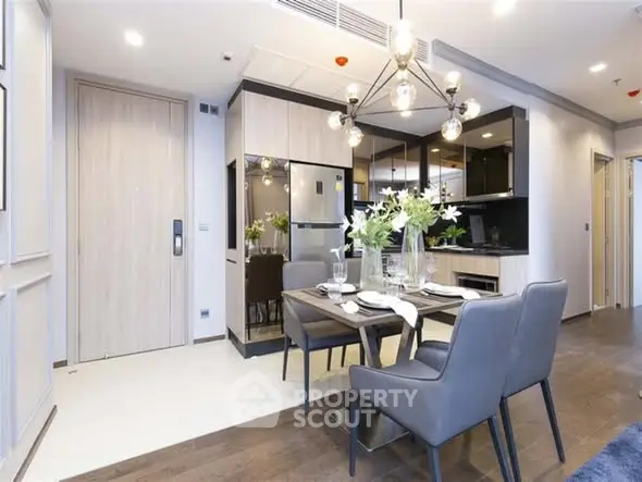 Modern dining area with elegant lighting and sleek kitchen design.