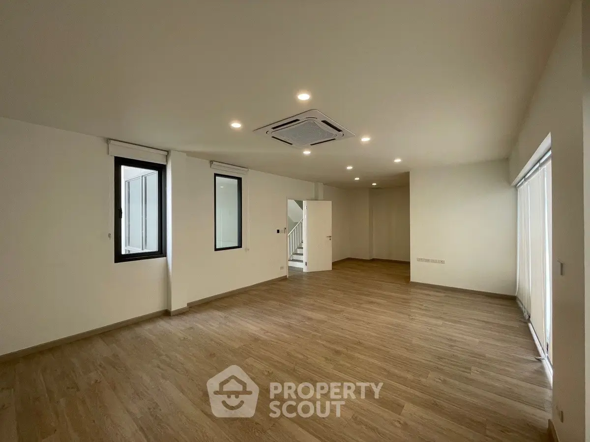 Spacious modern living room with wooden flooring and recessed lighting