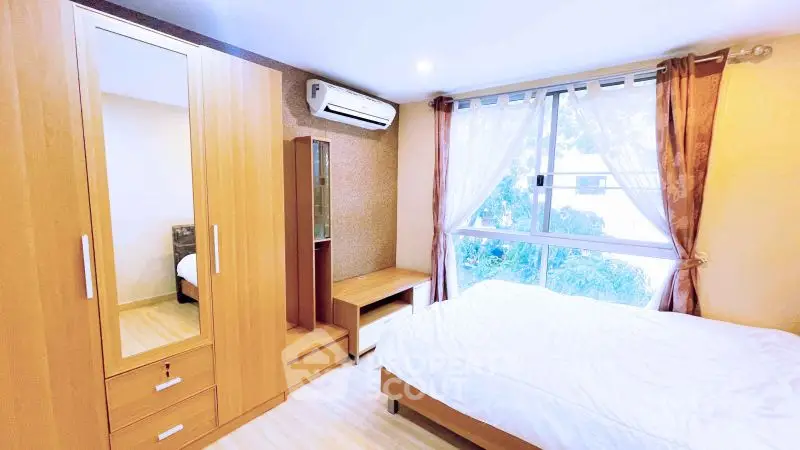 Bright and cozy bedroom with large window and wooden furniture