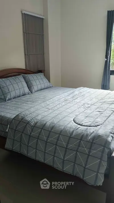 Cozy bedroom with stylish bedding and natural light, perfect for relaxation.