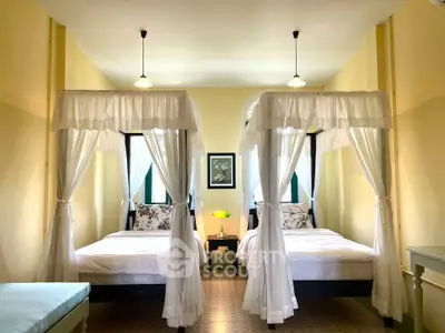 Charming bedroom with elegant canopy beds and soft lighting, perfect for a cozy retreat.