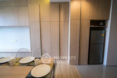 Modern kitchen with sleek wooden cabinetry and dining setup
