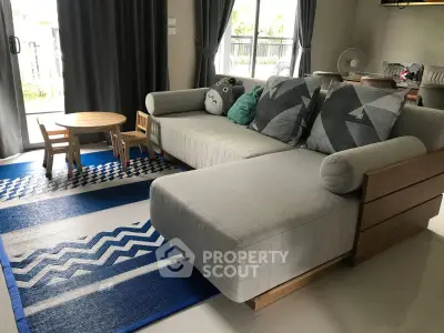 Spacious living room with modern sofa and playful decor, perfect for family gatherings.
