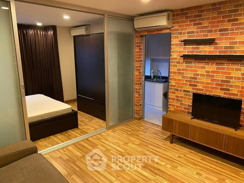 Modern apartment with brick accent wall, sliding glass doors, and cozy living area.