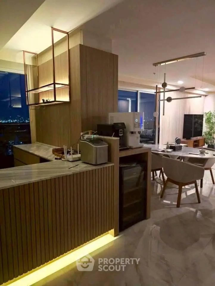 Luxurious open-plan living room with modern kitchen and stunning city view.