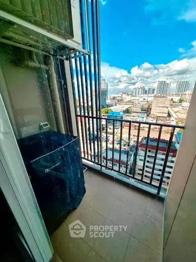 Stunning city view from a high-rise balcony with clear blue skies.