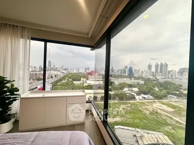 Stunning cityscape view from modern high-rise bedroom with large windows.